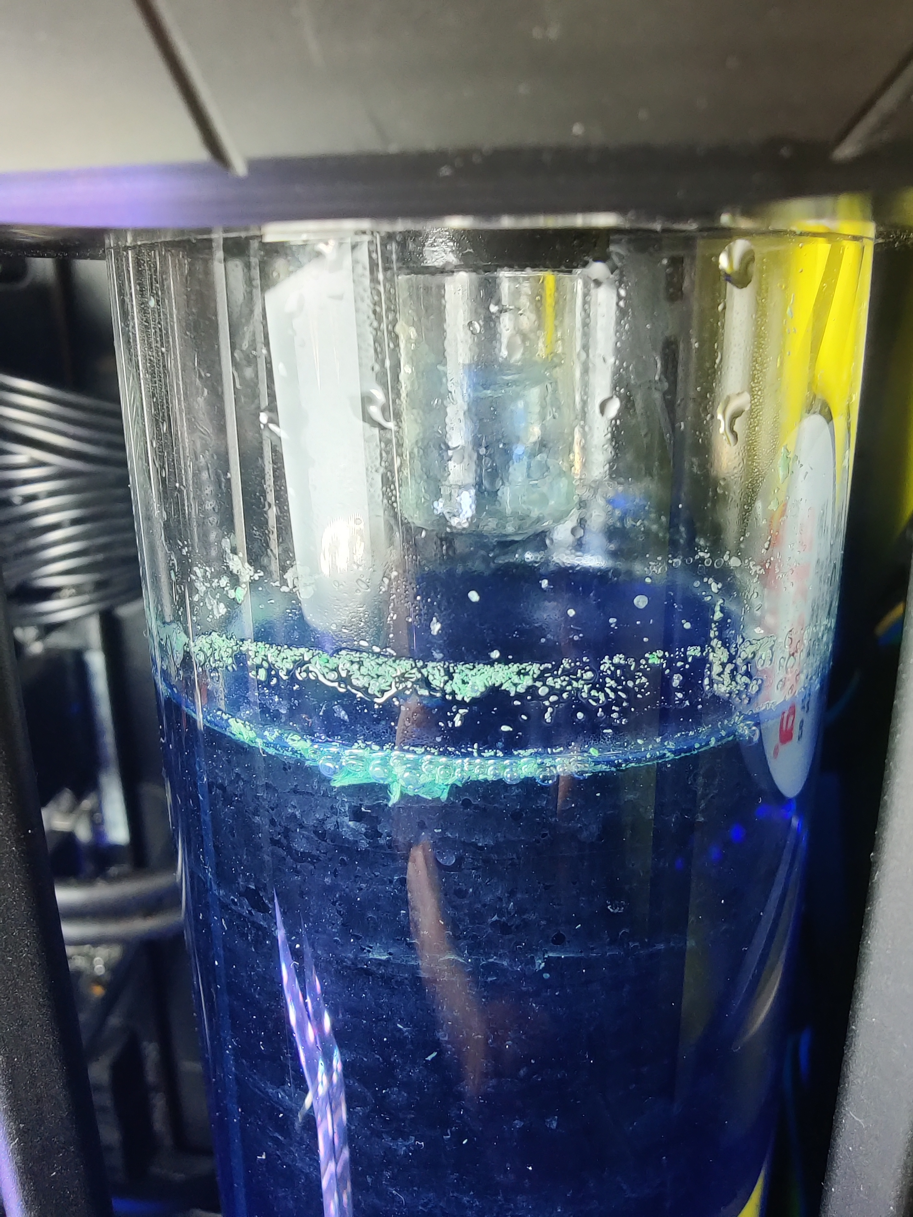 reservoir with blue tinted liquid and light green particles
